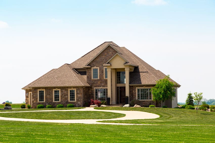 Monochromatic house with angled roof, windows, porch, and landscaped lawn