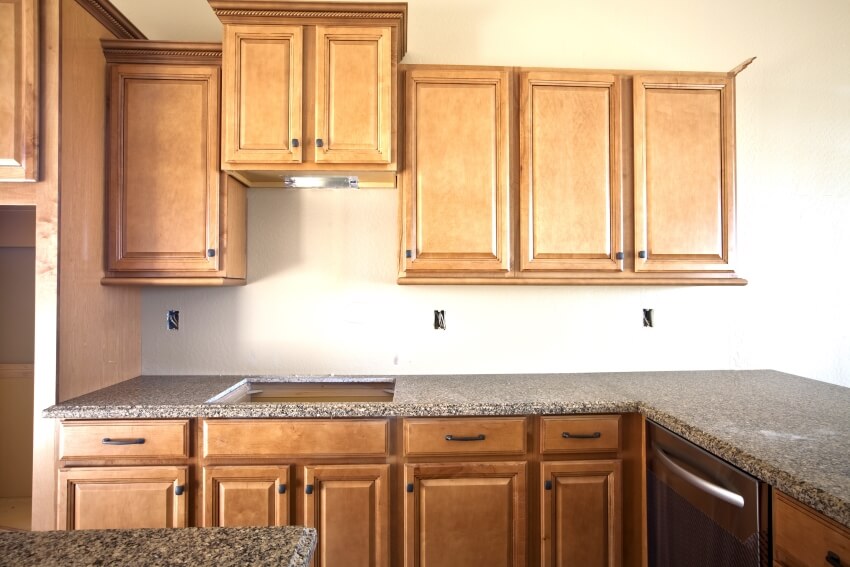 New empty kitchen with wooden cabinets and tropic brown granite countertops