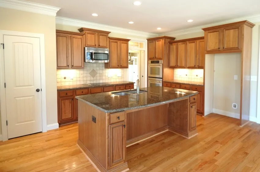 New kitchen with autumn brown granite countertops, wooden floor and cabinets