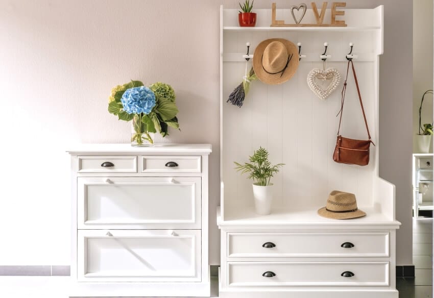 Organized white dressers with plants and hats