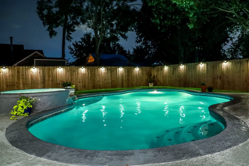 Outdoor area with low voltage fence lights, swimming pool, and jacuzzi