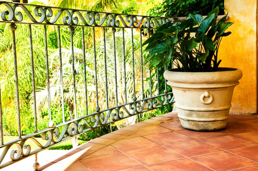 Outdoor area with metal railing, potted plant, and Saltillo tile floors