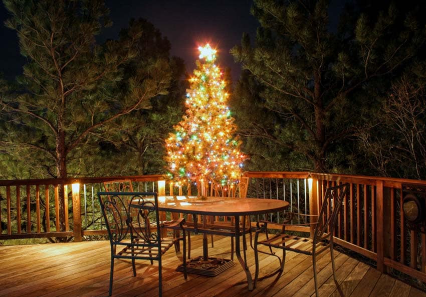 Outdoor patio with fence, table, chairs, Christmas tree