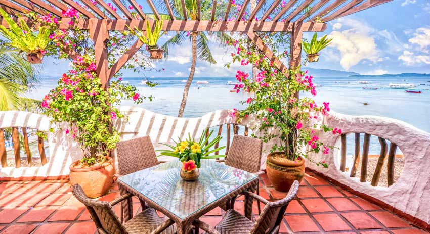 Patio with pergola, rattan table and chairs and flowering vines