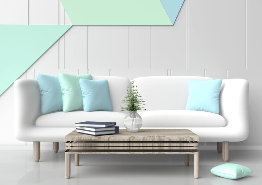 Pastel room with white sofa, table and geometric design accent on wall