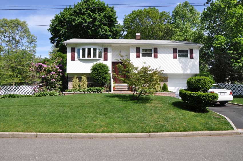 Raised style farmhouse with bow window and front lawn