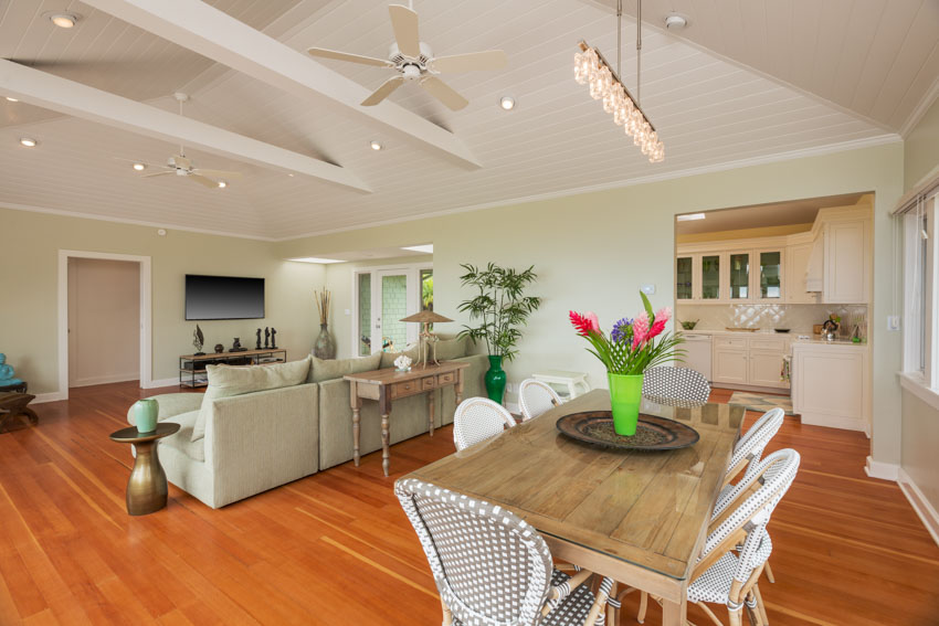 Interior of a home with sofa, rustic dining table and rattan chairs