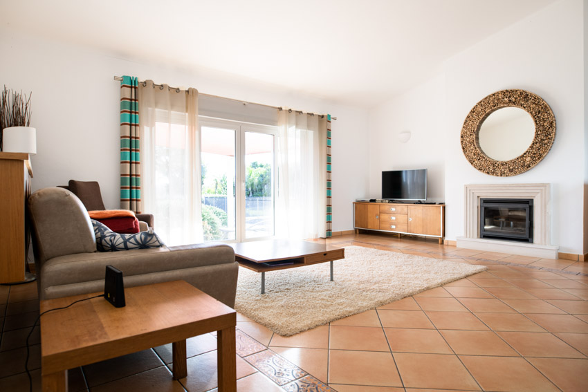 Room with sofa, center table, accent wall mirror and rug