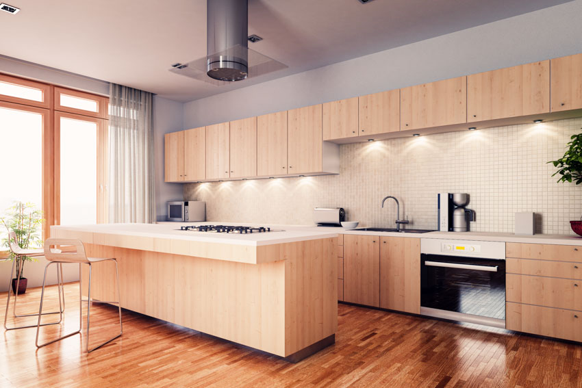 Kitchen with breakfast bar, under cabinet lighting, sheer curtains and stools