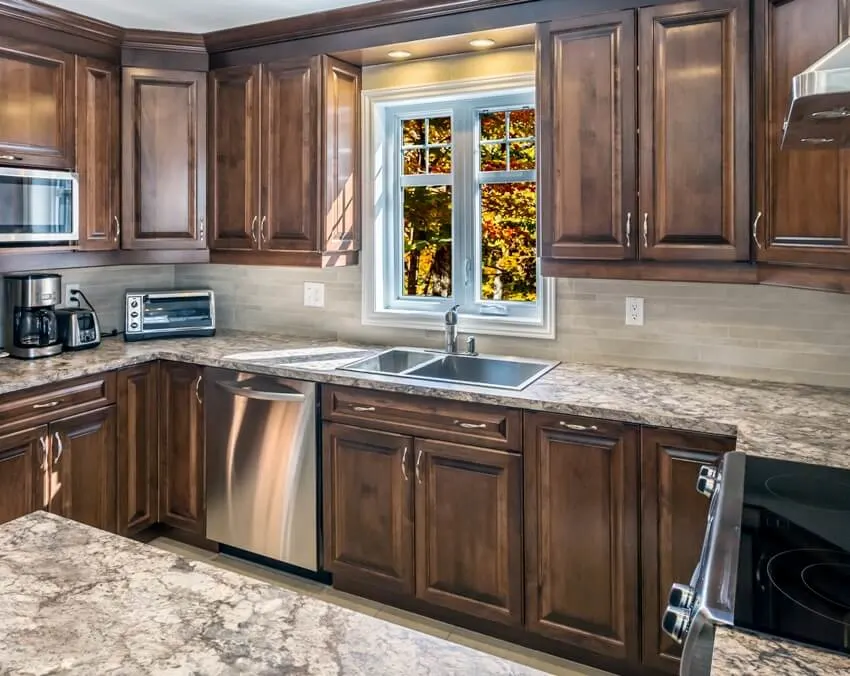 Spacious kitchen with marble floors and countertops, hardwood cabinets and drop in sink