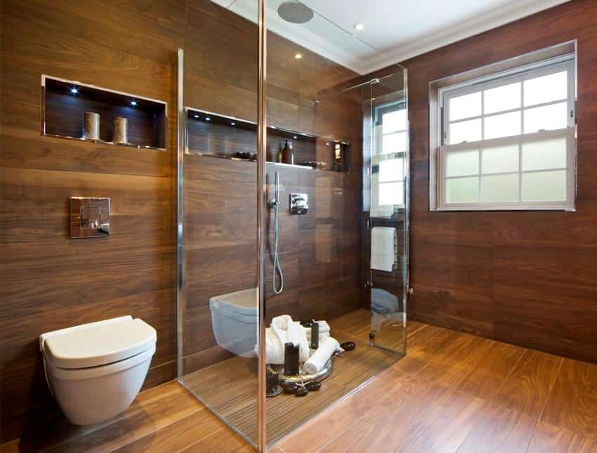 Stunning bathroom interior in a luxury new home with glass screen, enclosed shower area and wood looking tiles floor and walls