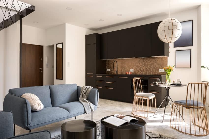 Stylish apartment with modern dining space, copper penny tile backsplash, and blue sofa