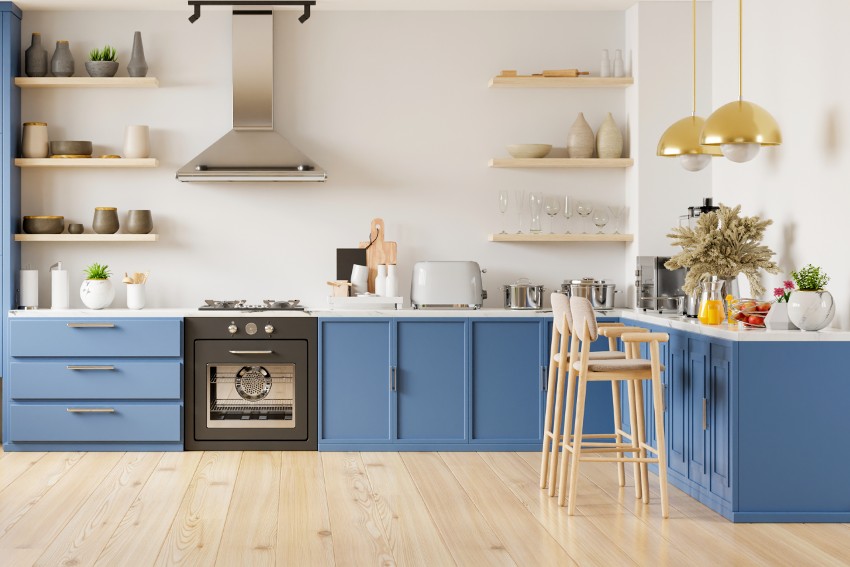Stylish kitchen interior with white walls, laminate wood floors, blue cabinets and floating shelves