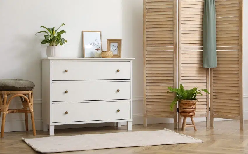 Stylish room with wooden folding screen, indoor plants, and a dresser