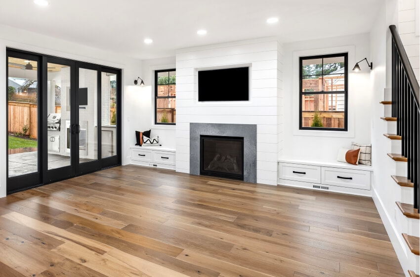 White farmhouse style living room with hardwood floors, nickel gap shiplap and sliding glass doors