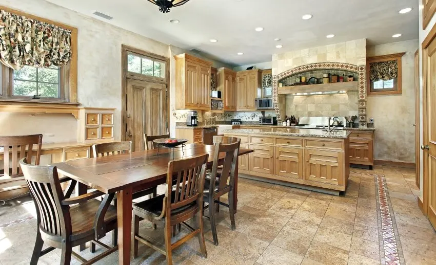 Wooden dining table and tile floor and backsplash in an arts and crafts designed kitchen