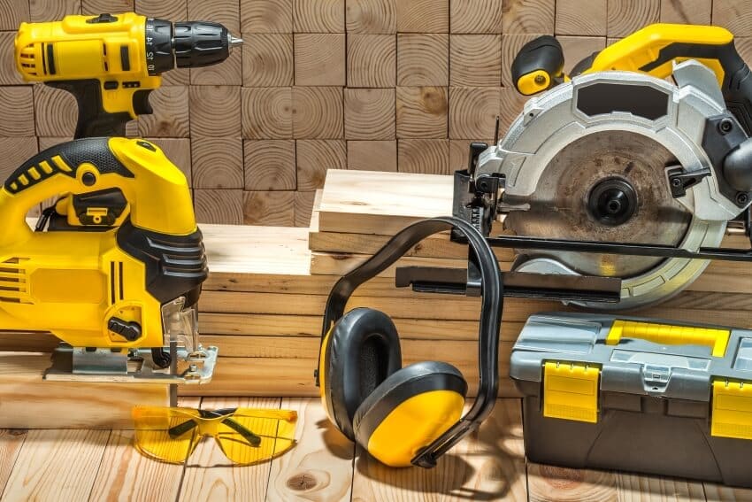Yellow construction carpentry power tools on wooden background