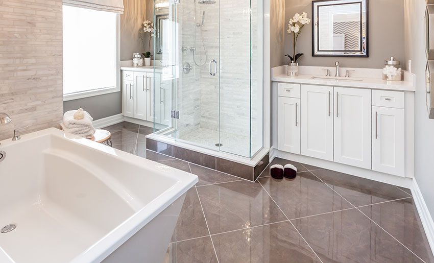 Bathroom with black diagonal tile frameless shower door bath tub vanity sink cabinets