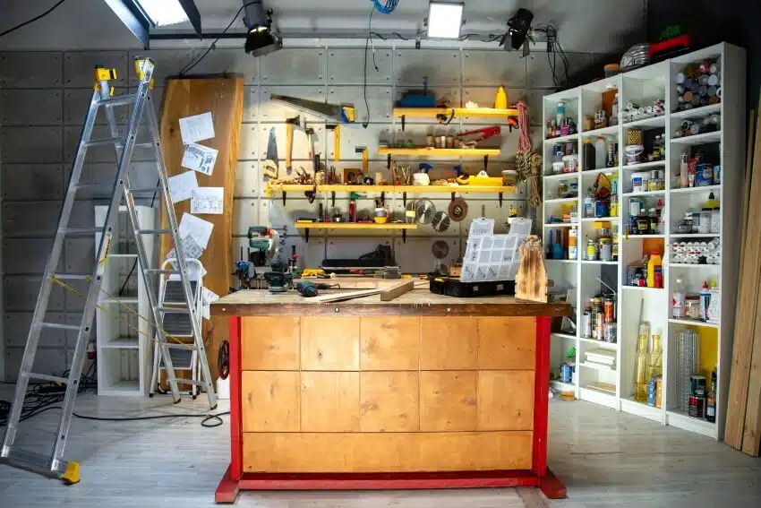A workshop with ladder, and accessories on floating shelves and cubby storage