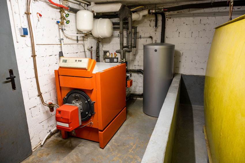 Basement with white brick walls, boiler, and oil furnace