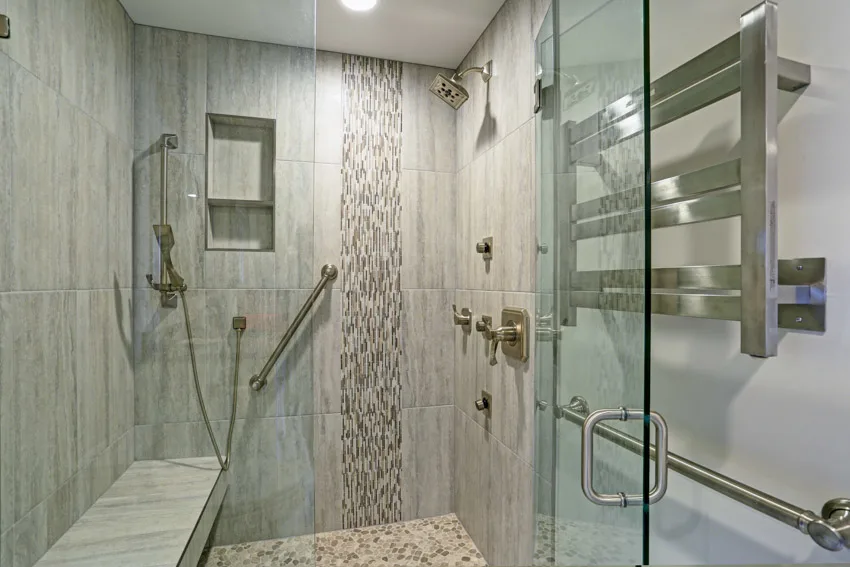 Bathroom with glass tile waterfall shower, shower head, ceiling light, towel holder, and glass door