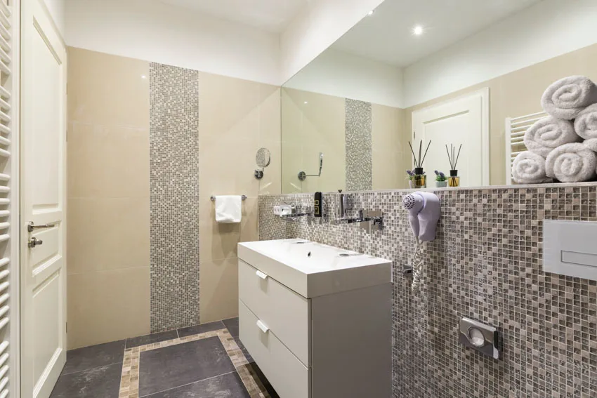 Bathroom with mosaic tile waterfall shower, floating vanity, sink, drawer, and mirror