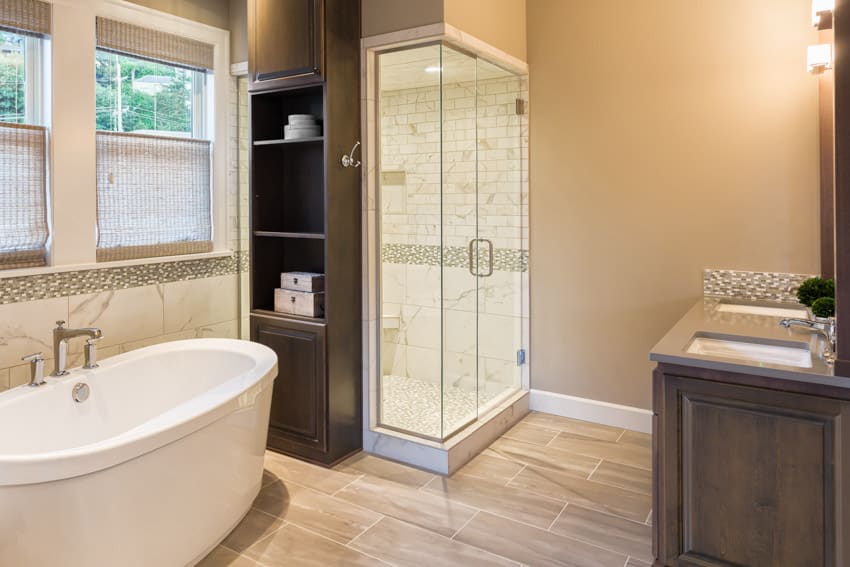 Bathroom with shower enclosure, tub, tile wall, wood flooring, window, and vanity area