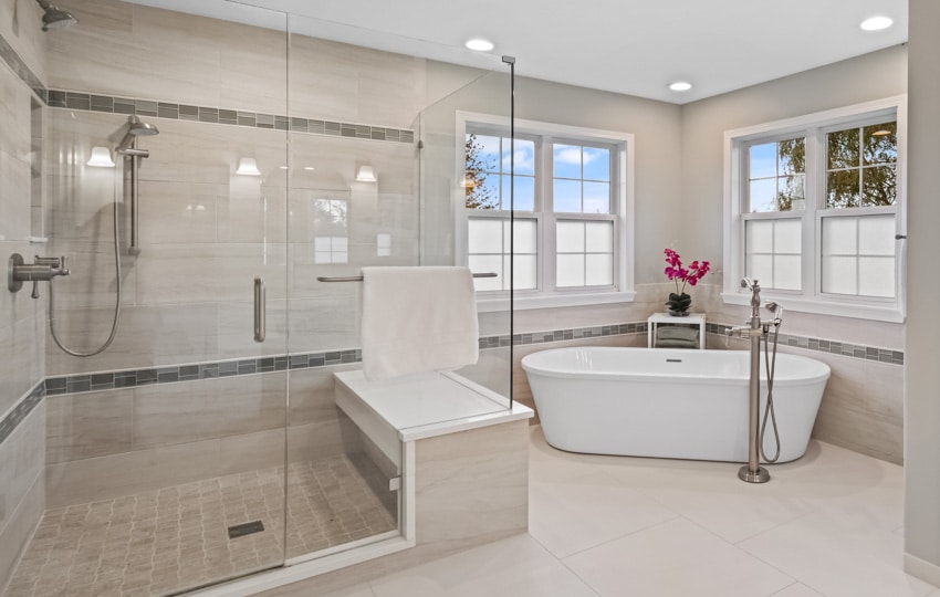 Bathroom with shower glass door, tub, travertine and listello tile, ceiling lights, and windows