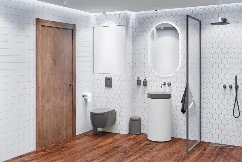 Bathroom with shower hexagon tile backsplash, mirror, sink, toilet, glass divider, and wood floors
