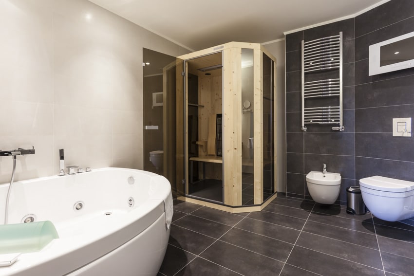 Bathroom with toilet, bidet, tub and tile flooring