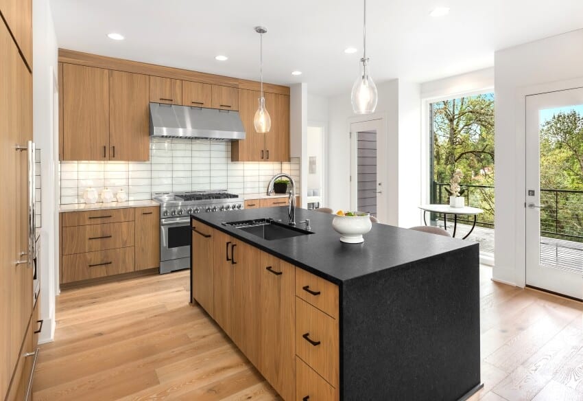 Beautiful kitchen with waterfall quartz island, pendant lights, and modern natural wood cabinets