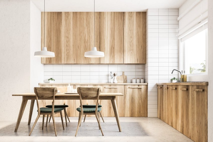 Beautiful scandinavian kitchen with a concrete floor, light okoume plywood countertops and table with black chairs