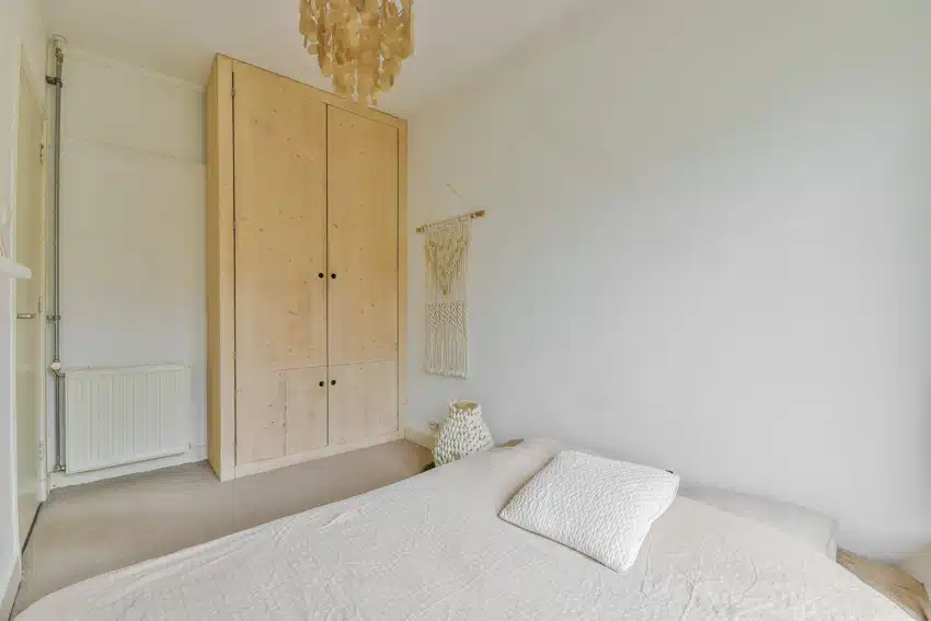 Bedroom with DIY armoire made of wood, bed, and white walls