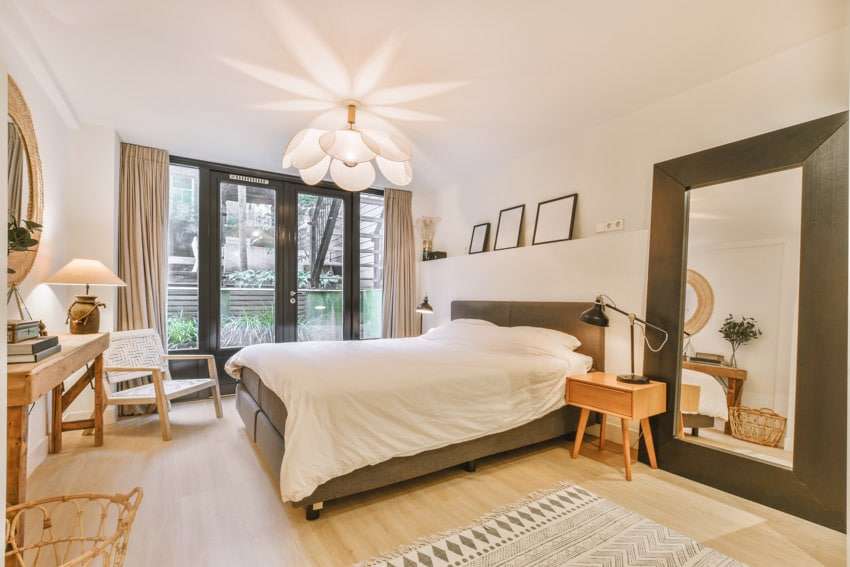 Bedroom with ambient lighting, mirror, vanity table, curtains, and ceiling light