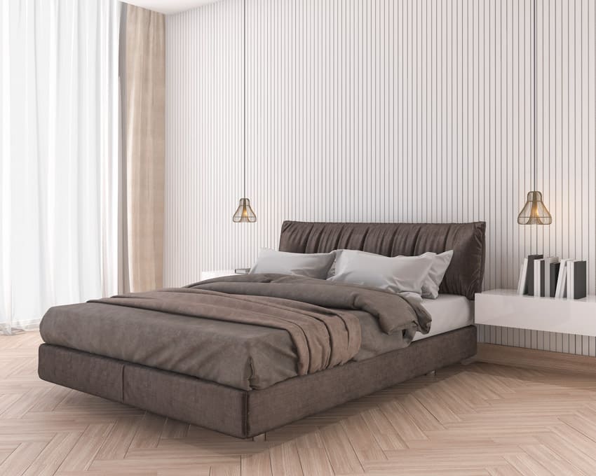 Bedroom with brown bedding, headboard, pillows, nightstand and pendant lights