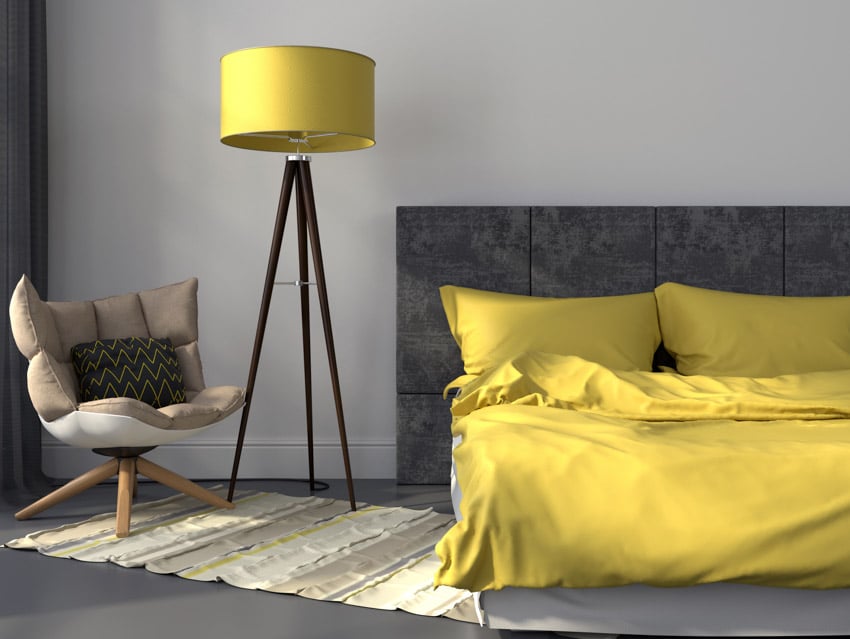 Bedroom with club lamp, headboard, yellow comforter and accent chair