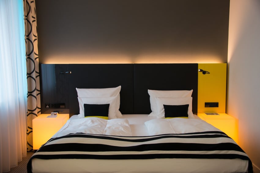 Bedroom with furniture, mounted lighting, black and white bedding and curtains