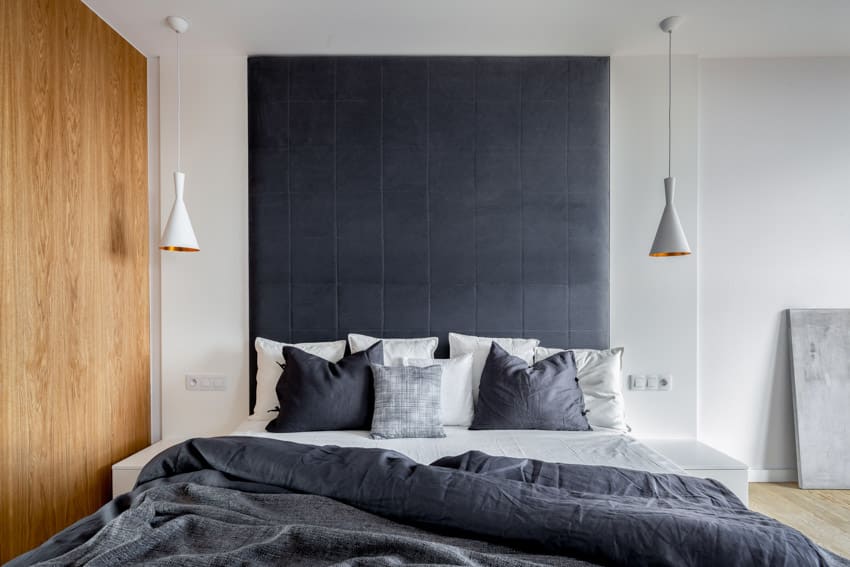 Bedroom with headboard, pendant lights and gray pillows