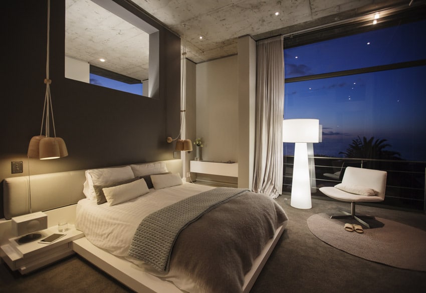 Bedroom with white floor lamp, futon bed and grey carpet