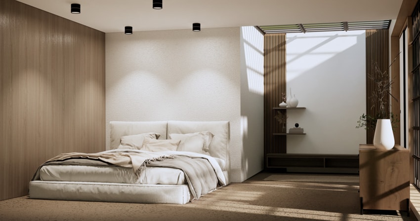 Bedroom with white mattress, ceiling llights, pillows, shelves, wood slat wallsand white vase