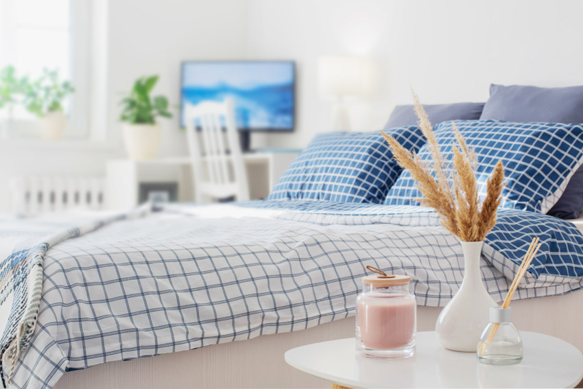 Bud vase, blue pillows, and bedding