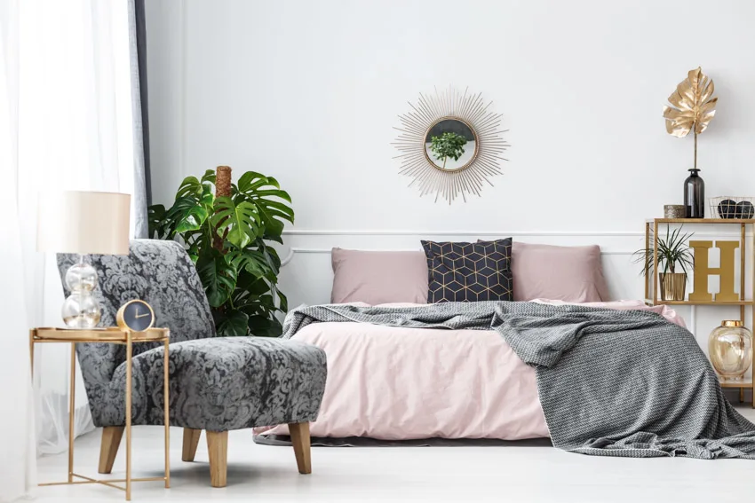 Bedroom with romantic color combinations, pillows, chair, shelves, and indoor plants