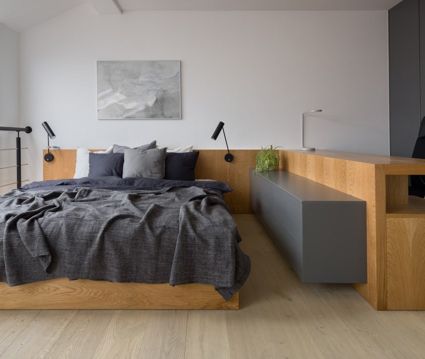 Bedroom with task lighting fixtures, comforter, pillows and floating dresser