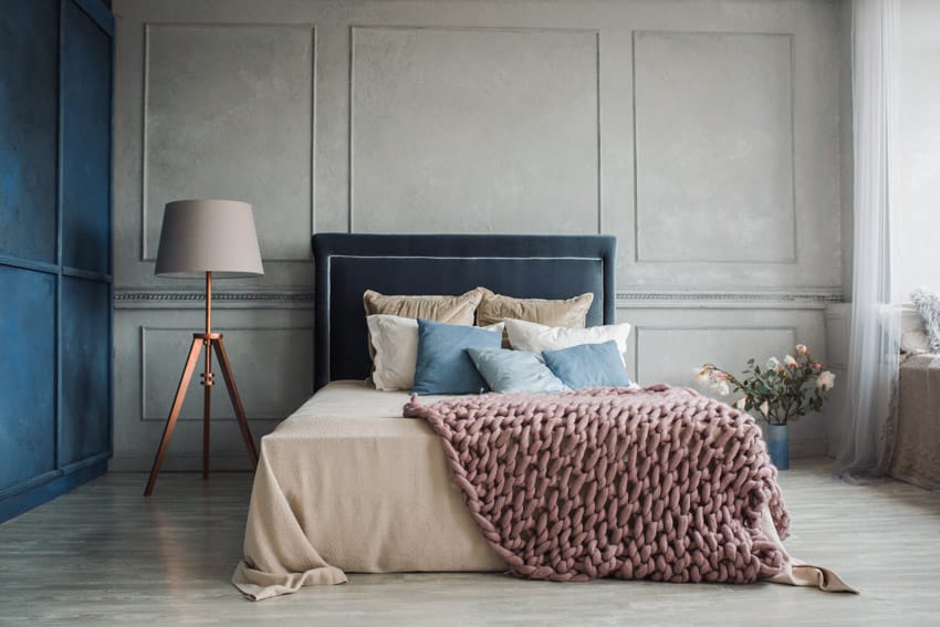 Bedroom with tray lamp, paneled walls, pillows, bedding and sheer curtains