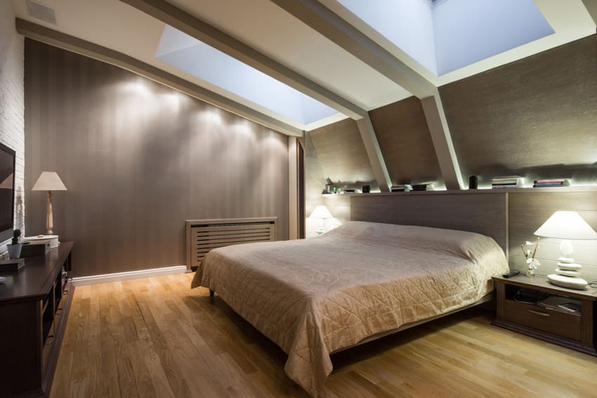 Bedroom with mattress, wood floors, nightstand, lamps, and skylight windows