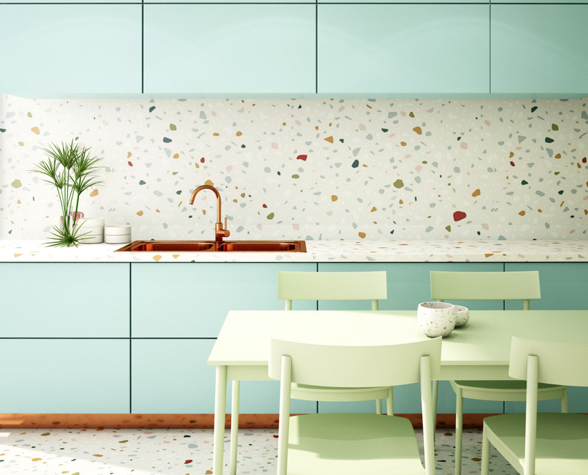 Bright modern kitchen with terrazzo recycled glass countertop, backsplash, green cabinets, chairs, and table