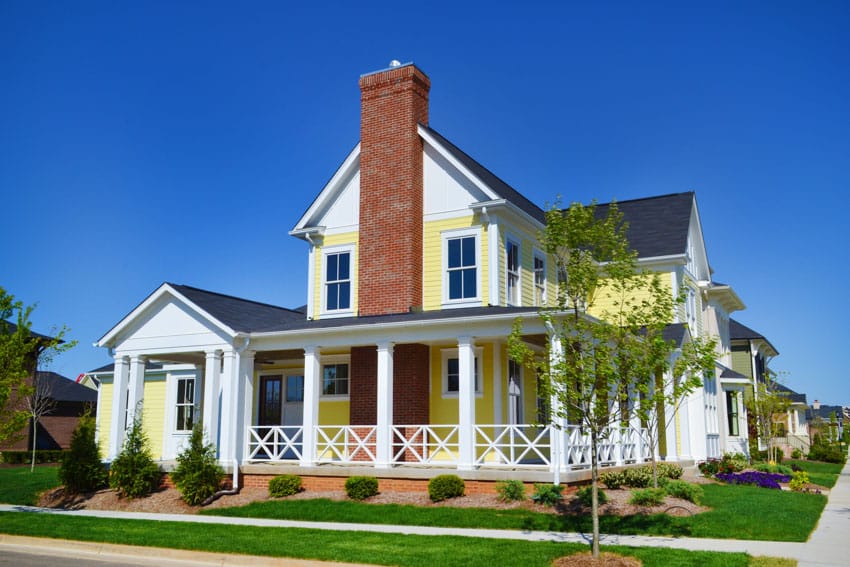 Yellow house with bright color, chimney, and white framed windows