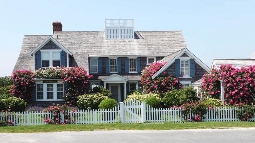 Cape cod house with exterior color combinations, dormer, windows, chimney, picket fence, windows, and front lawn