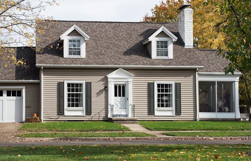 House with white front door, tan color, dormers, screened porch, chimney, and siding