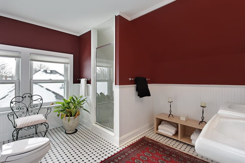 Contemporary bathroom with beadboard half wall, chair, indoor plant, toilet, and tile floors